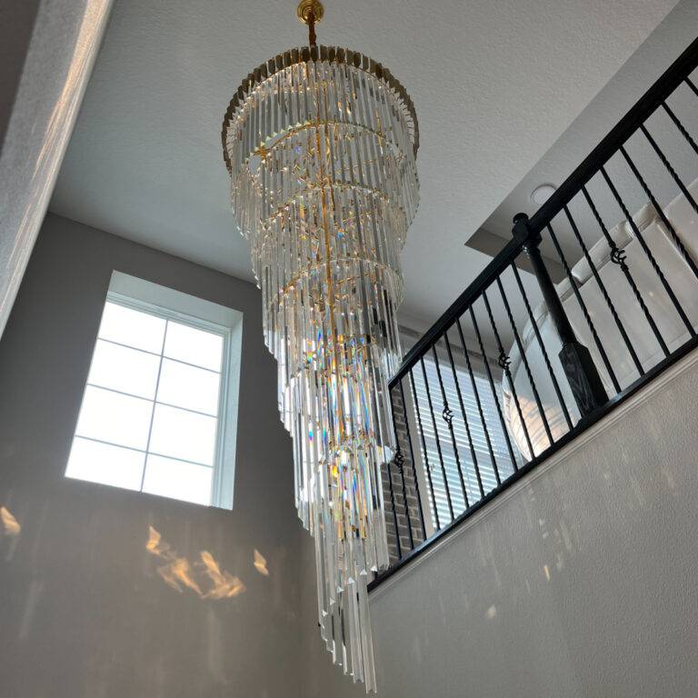 Luxury modern round crystal chandelier in a high ceiling staircase, featuring stainless steel frame and K9 crystals.