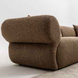 Close-up view of the Puffy Sofa showcasing its textured brown fabric and rounded armrest design.