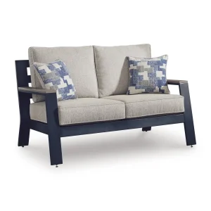 Three-quarter angle view of Sile navy blue outdoor loveseat with driftwood-look arms, beige cushions, and geometric throw pillows