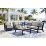 Sile navy blue outdoor loveseat and collection arranged on poolside patio with blue patterned rug and tropical landscaping