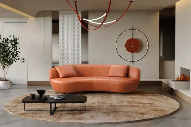 Modern living room with a curved, cognac brown real leather sofa, marble coffee table, and minimalist decor.
