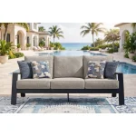 Sile navy blue outdoor sofa styled on poolside patio with infinity pool, ocean view, and Mediterranean-style home in background
