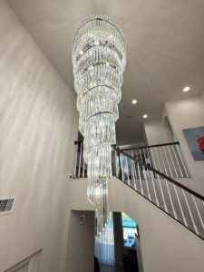 Luxury Staircase Chandelier – 8 ft high ceiling chandelier with K9 crystals in a modern home.