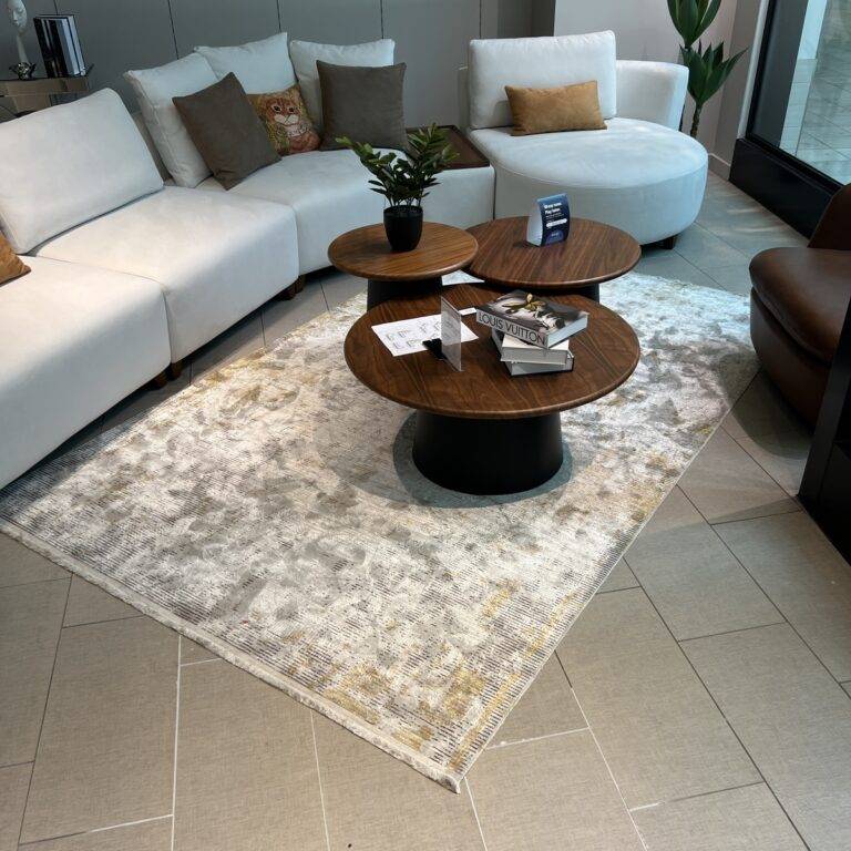Turkish rug with intricate patterns in shades of grey and gold on display at De’Luxe Home Decor & Furniture in Tampa.