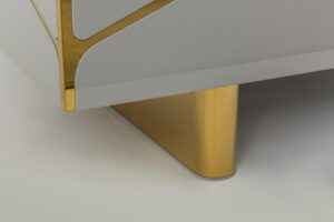 Close-up of a modern luxury TV stand's gold-accented leg.