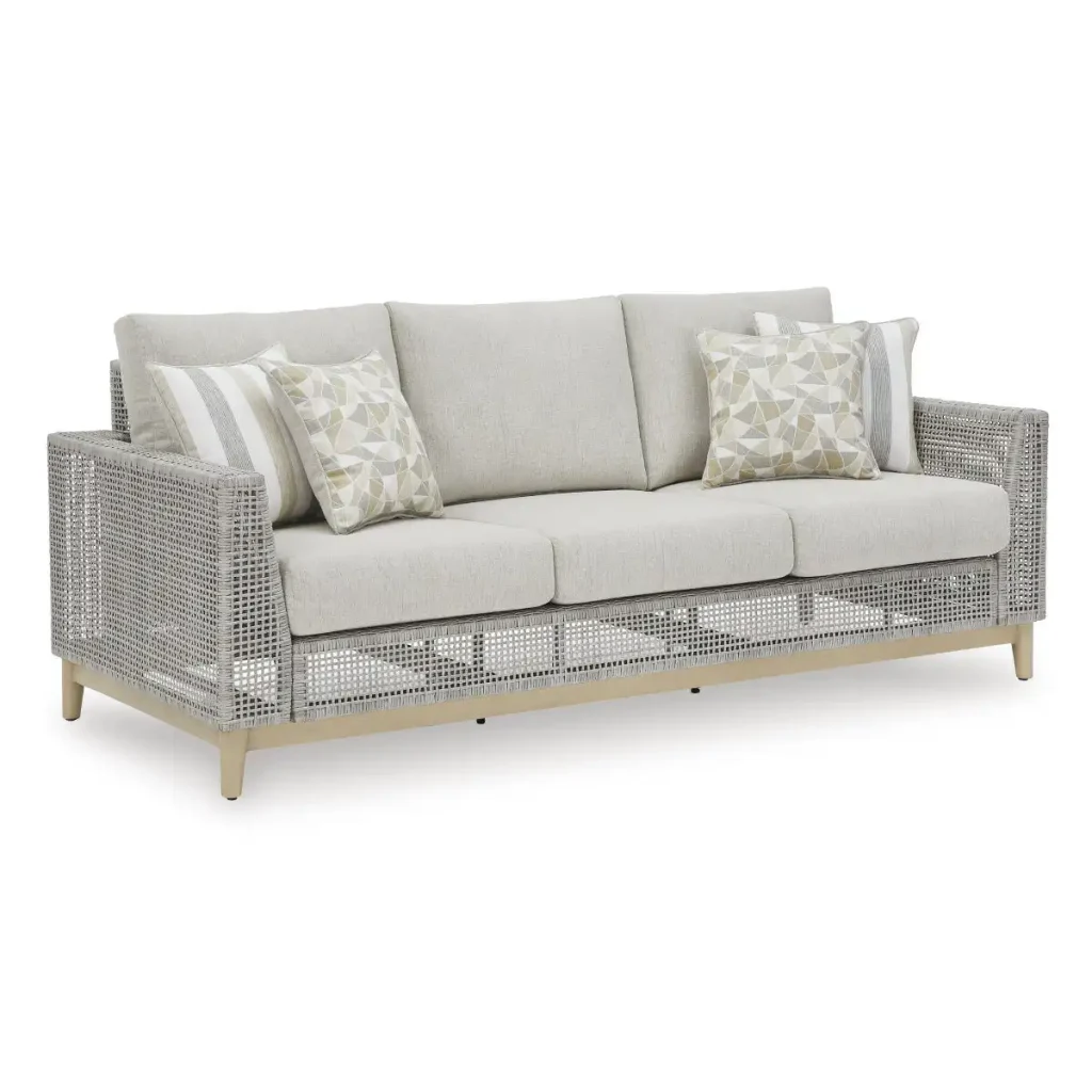 Angled front view of Yali gray outdoor sofa with gray resin wicker, light gray cushions, wood-look legs, and geometric throw pillows
