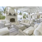 Yalı gray outdoor sofa collection arranged on covered patio with fireplace, swivel chairs, coffee table, and striped outdoor rug