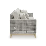 Side profile of Yalı gray outdoor sofa showing detailed resin wicker weave pattern, cushion depth, and wood-look leg construction